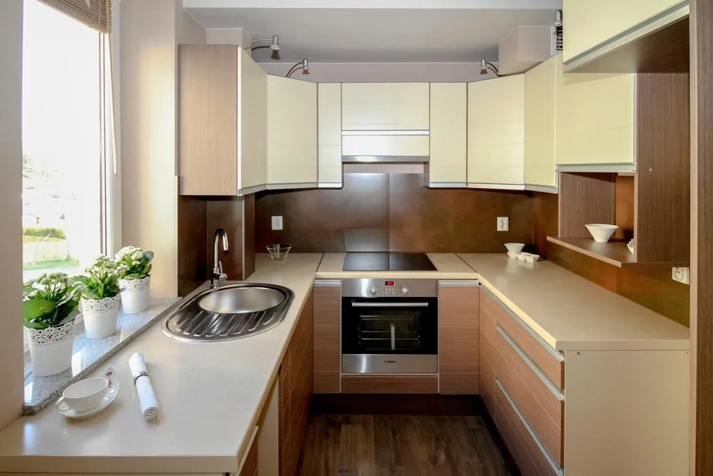 Cocina en forma de U con muebles de madera y blancos