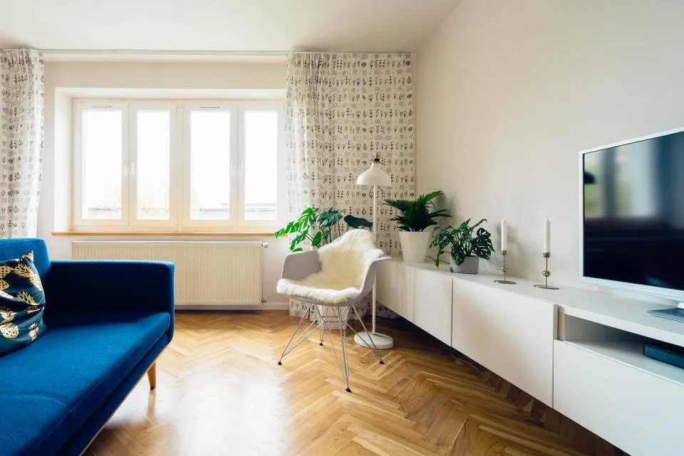 Salón luminoso recién pintado con suelo de espiga